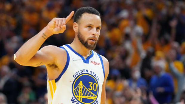 Stephen Curry holds one finger in the air.